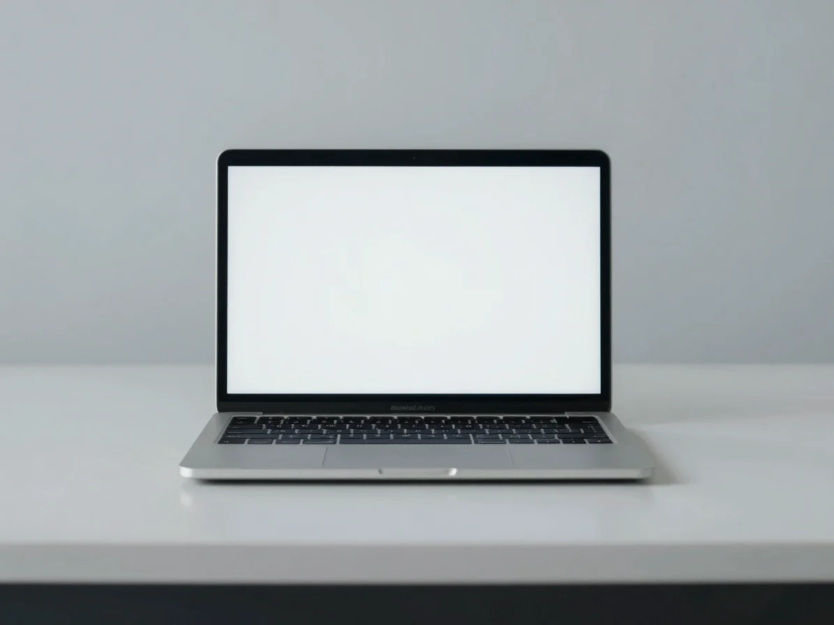 Uncluttered wide composition of a desk with a laptop showing a blank, non-specific market screen, controlled neutral stu